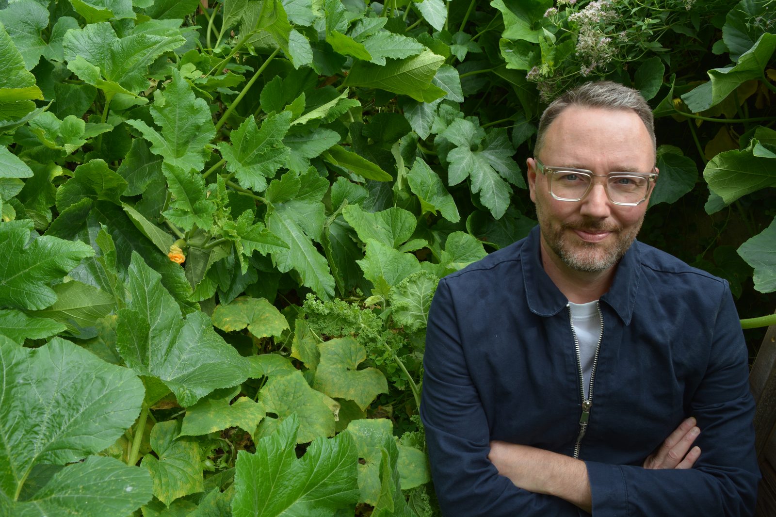 David Ruffieux, bras croisés et sourire discret, entouré d’une végétation luxuriante